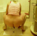 A blonde girl squats on the floor and takes a dump.
